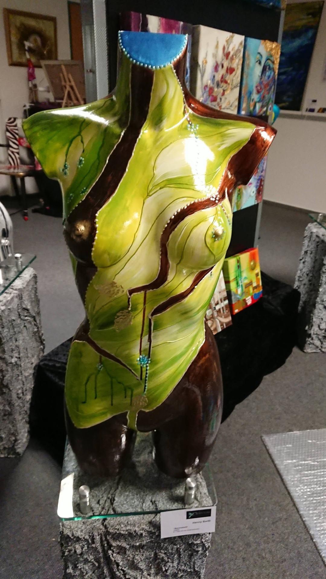 In einem Raum steht auf einem Glassockel eine Statue eines Frauentorsos.