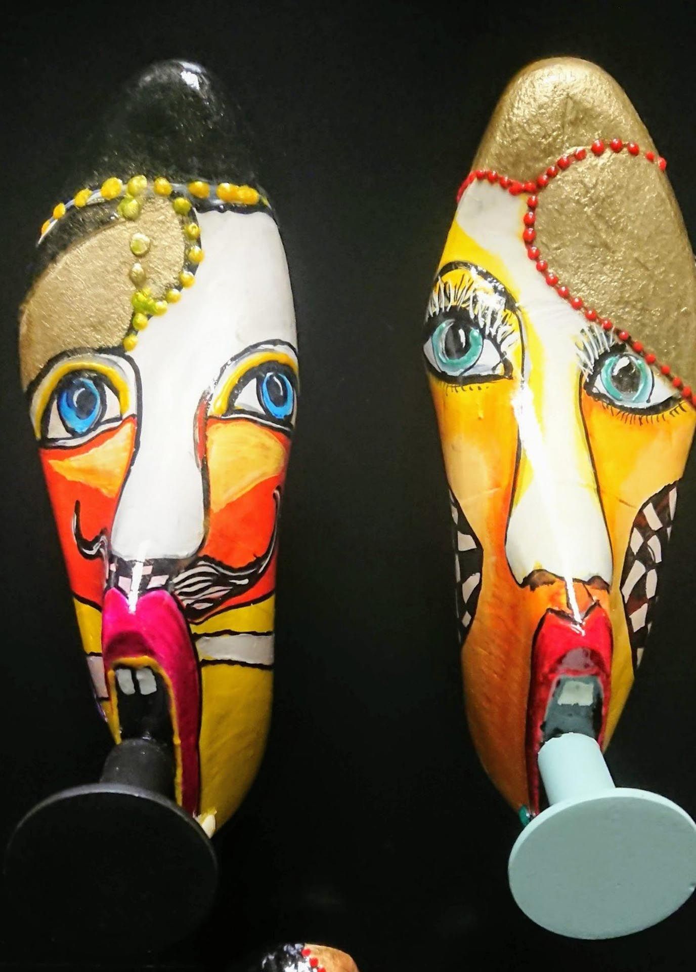 Zwei bunte Gesichter sitzen nebeneinander auf einem schwarzen Hintergrund