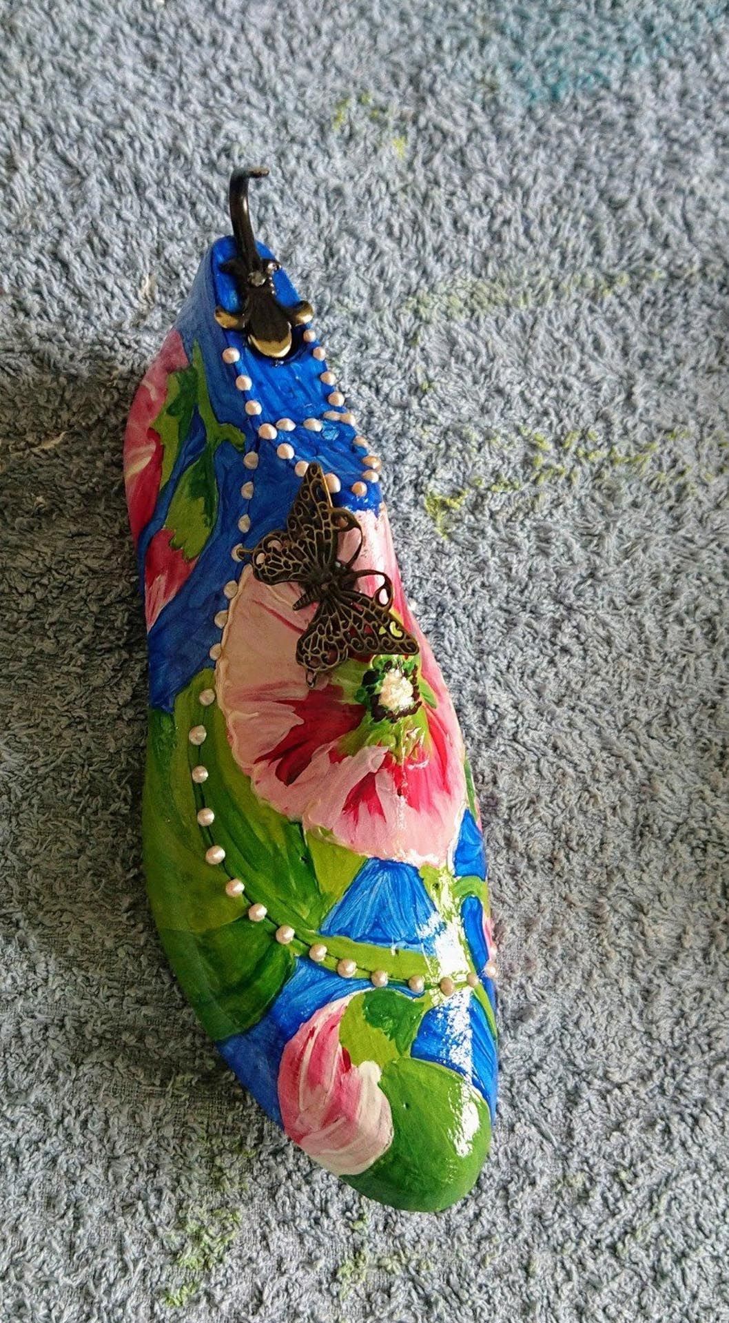 Eine farbenfrohe Schuhskulptur sitzt auf einem Teppich.