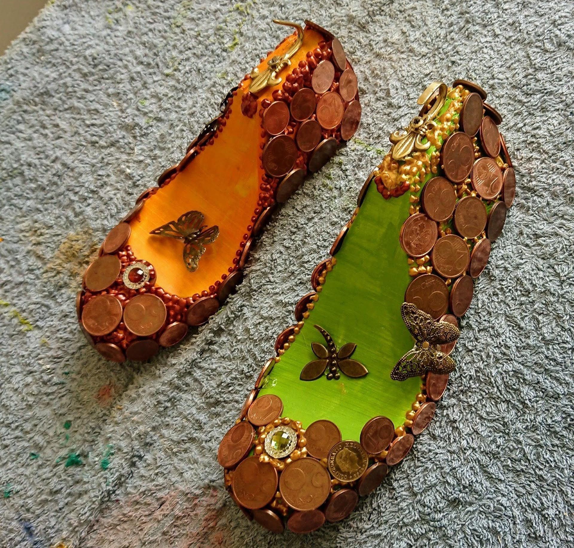 Ein Paar Schuhe aus Münzen und Schmetterlingen