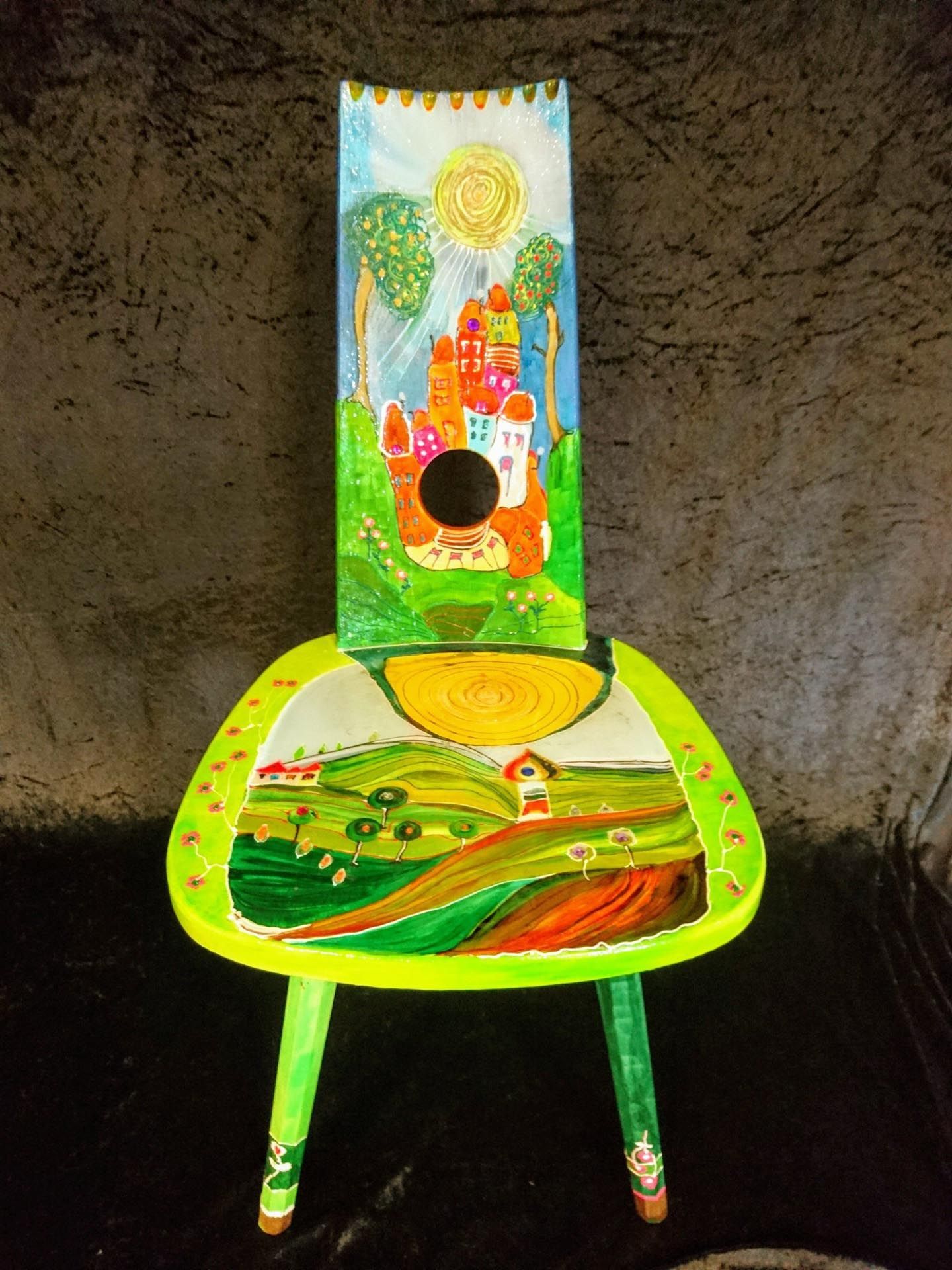 Ein grüner Stuhl mit einem Gemälde eines Schlosses darauf