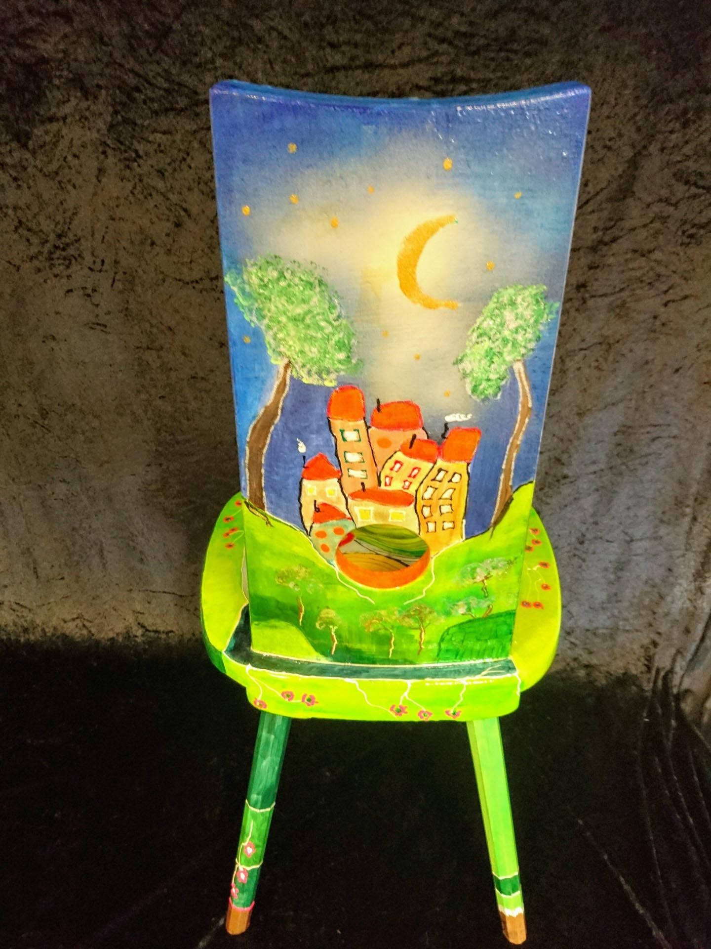 Ein grüner Stuhl mit einem Gemälde eines Schlosses darauf