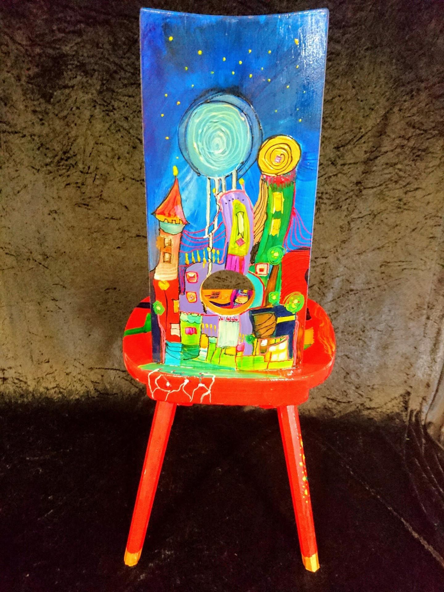 Ein roter Stuhl mit einem Gemälde auf der Rückenlehne