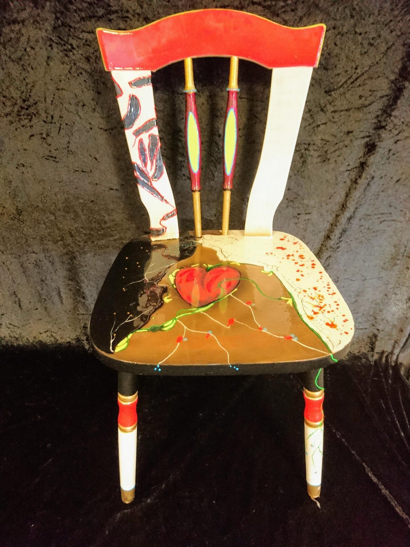 Ein bunter Stuhl mit einem Herz auf der Sitzfläche