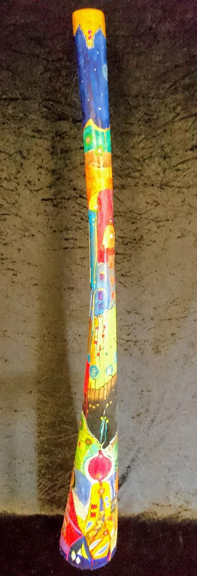 Ein farbenfroher Gegenstand steht auf einem Tisch vor einer Wand.