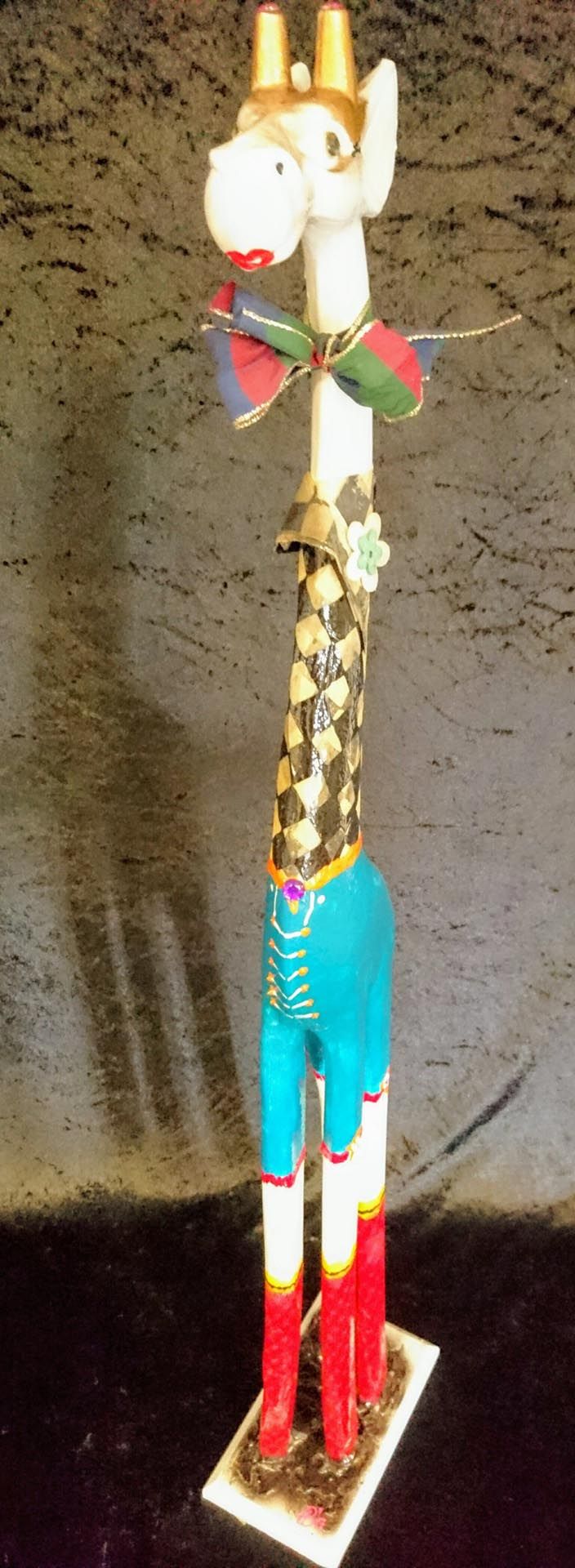 Eine Statue einer Giraffe mit Krone und Fliege.