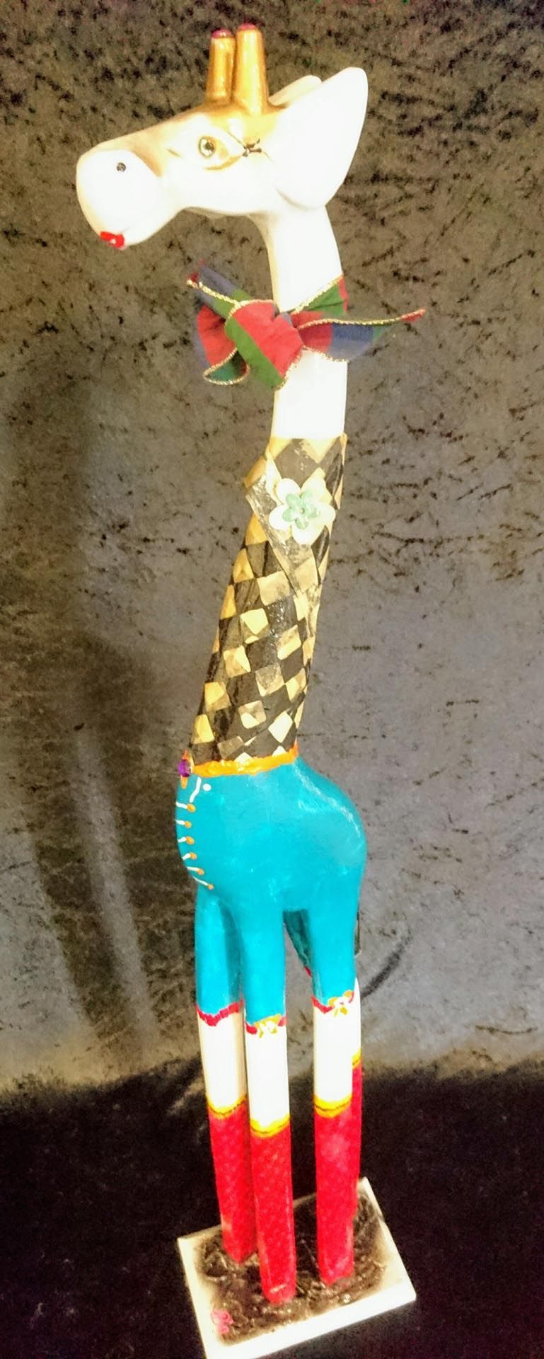 Eine Statue einer Giraffe mit Cowboyhut und blauen Shorts.