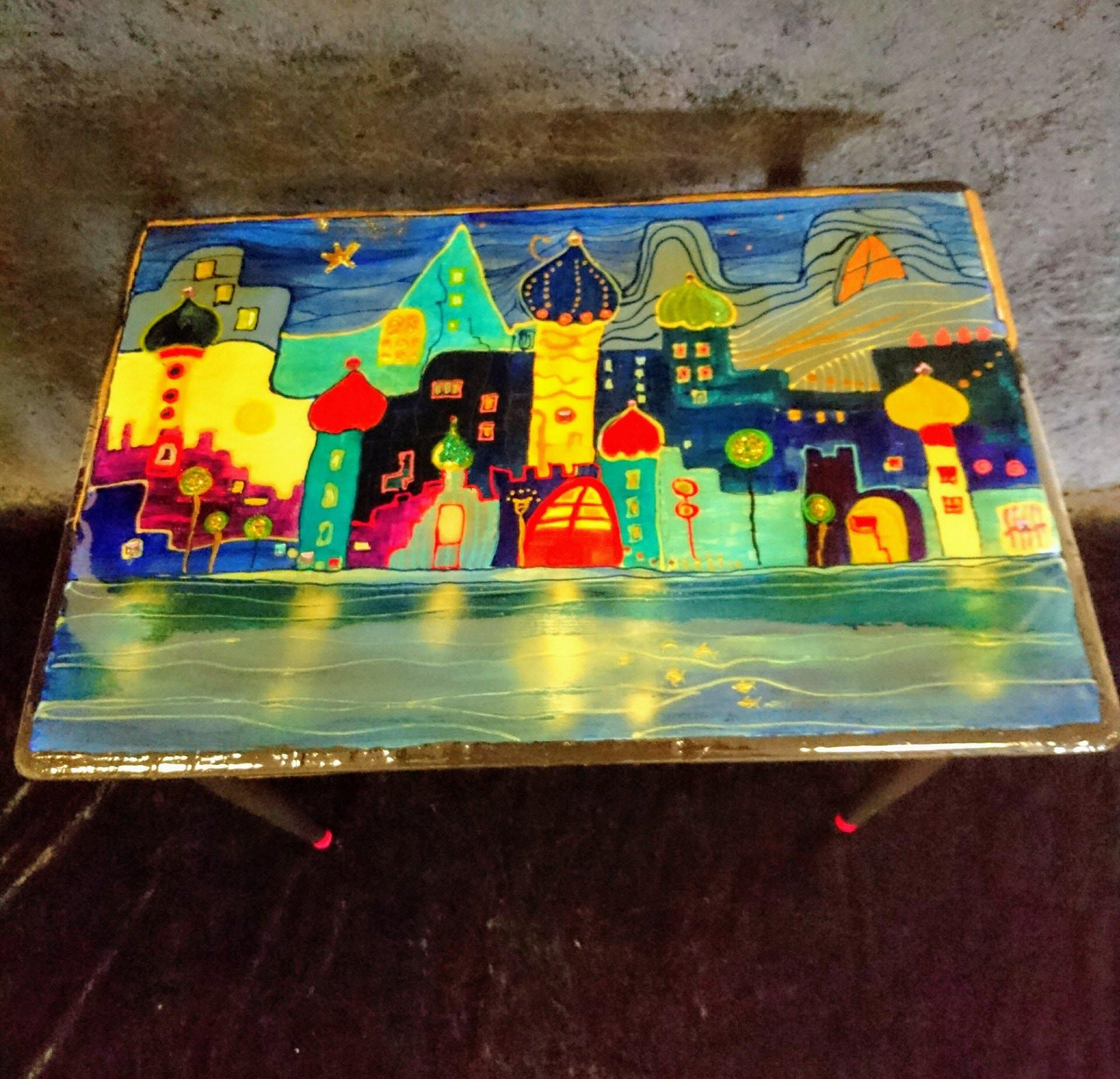 Ein Tisch mit einem Gemälde einer Stadt darauf