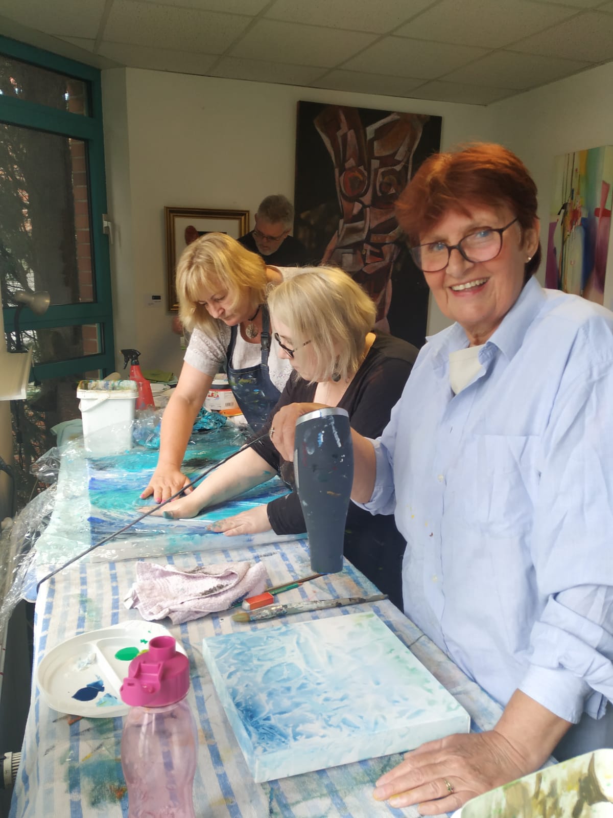 Eine Gruppe von Frauen sitzt an einem Tisch und malt