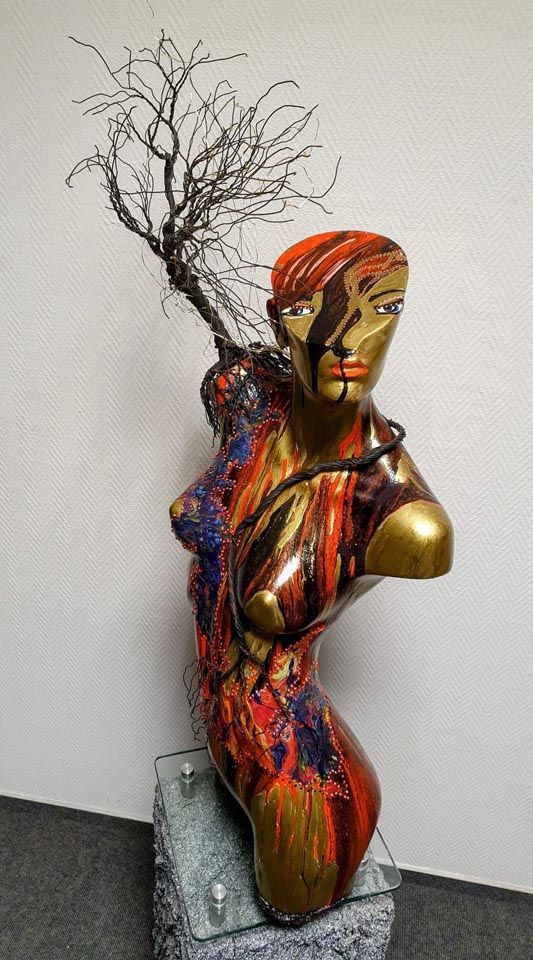 Eine Statue einer Frau, aus deren Kopf ein Baum wächst.