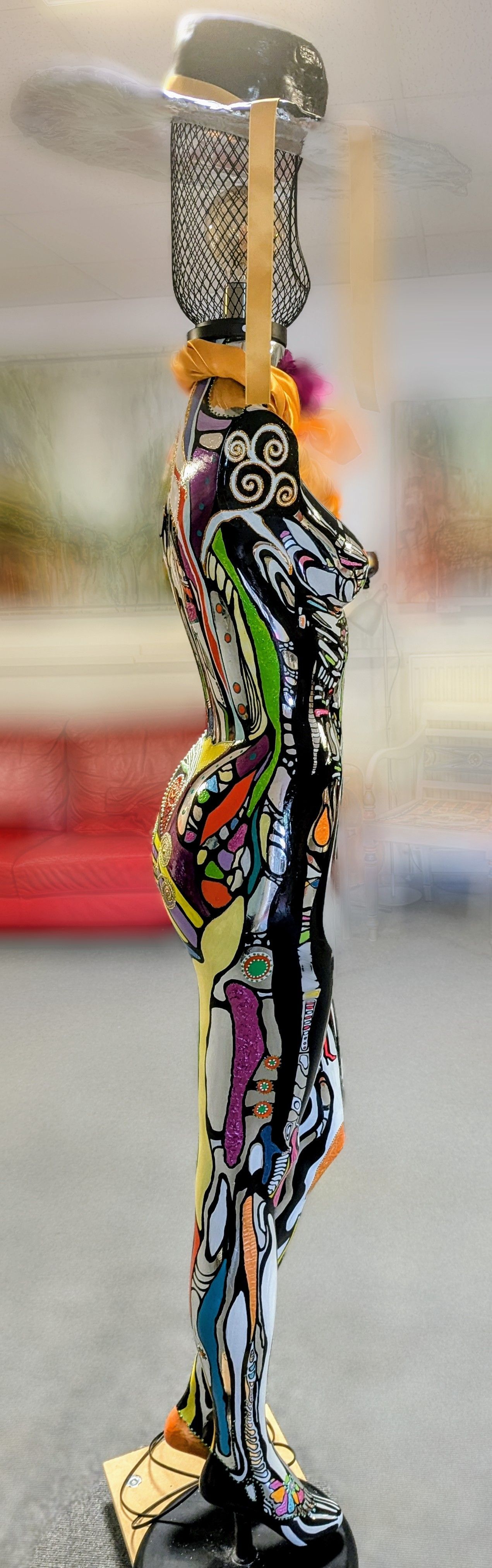 Auf einem Tisch steht eine farbenfrohe Frauenstatue.