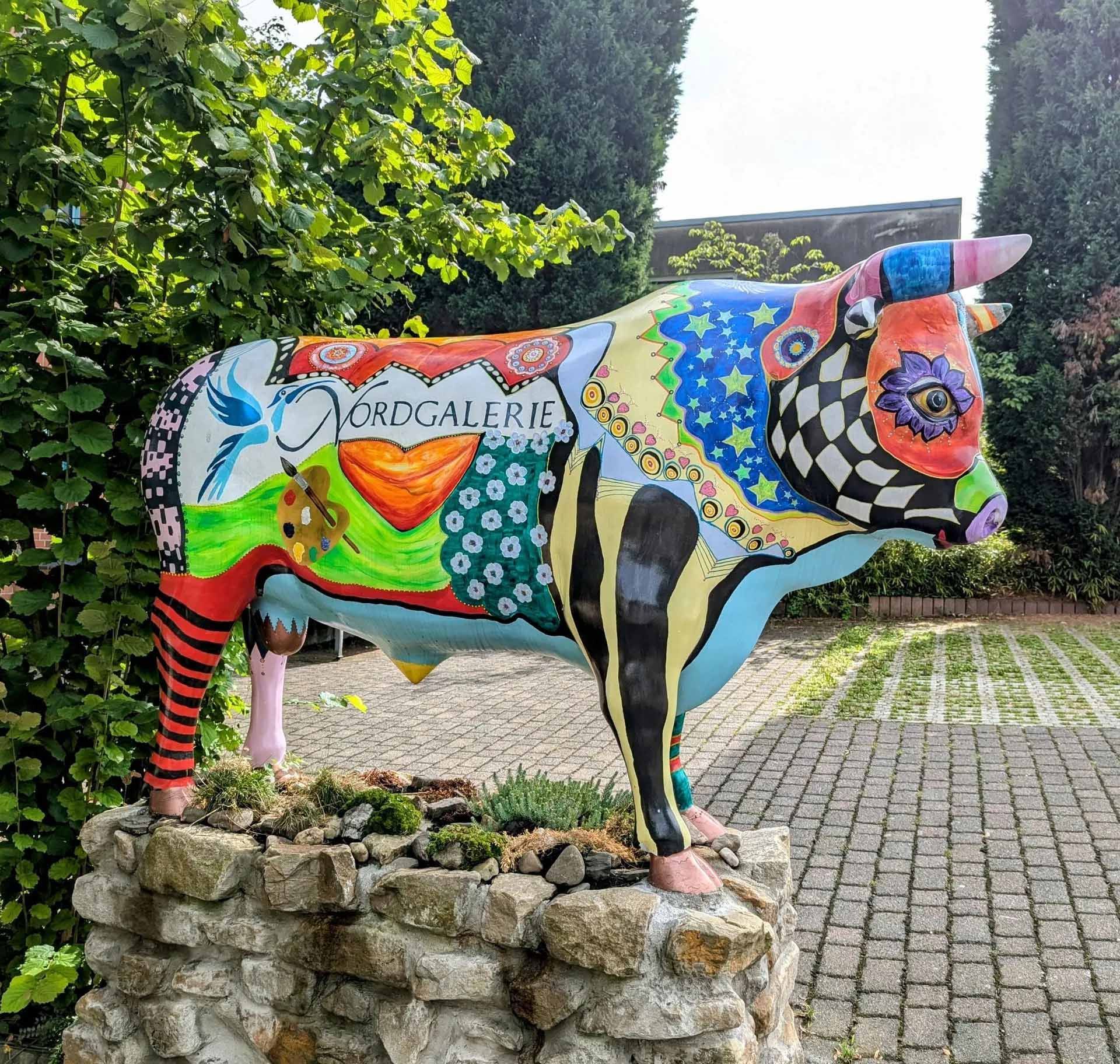 Eine bunte Statue einer Kuh mit dem Wort Eule darauf