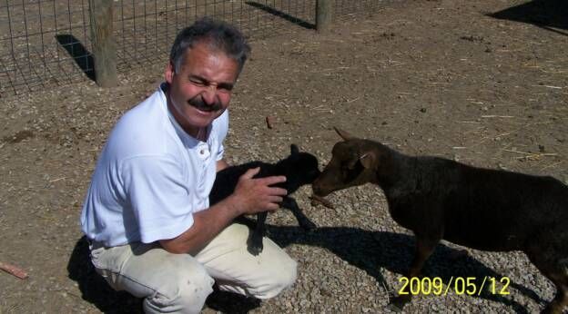 A man is petting a goat in a photo dated 2009/05/12