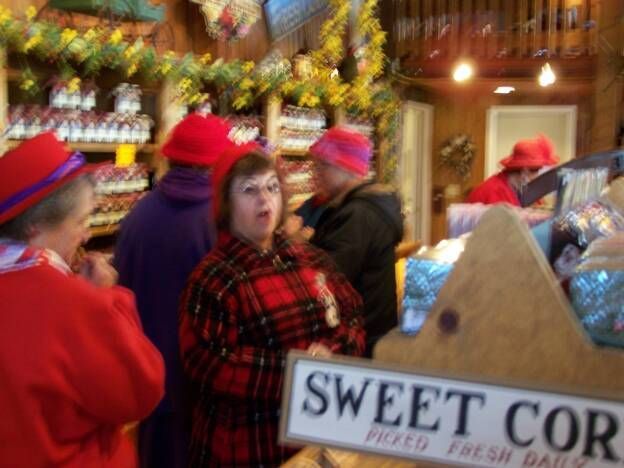 A group of people standing in front of a sign that says sweet corn