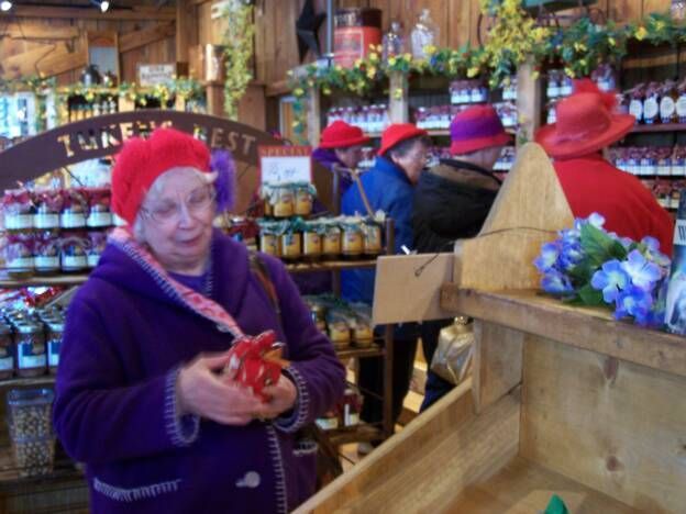 A woman in a red hat stands in front of a sign that says zucker nest