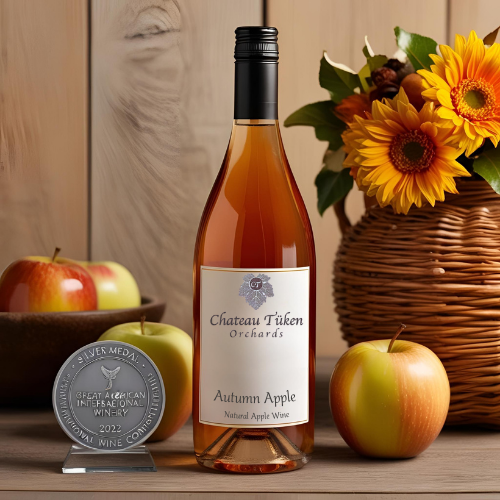 A bottle of autumn apple wine sits on a wooden table
