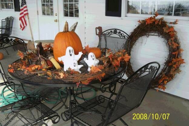 A table decorated for halloween with pumpkins and ghosts on it