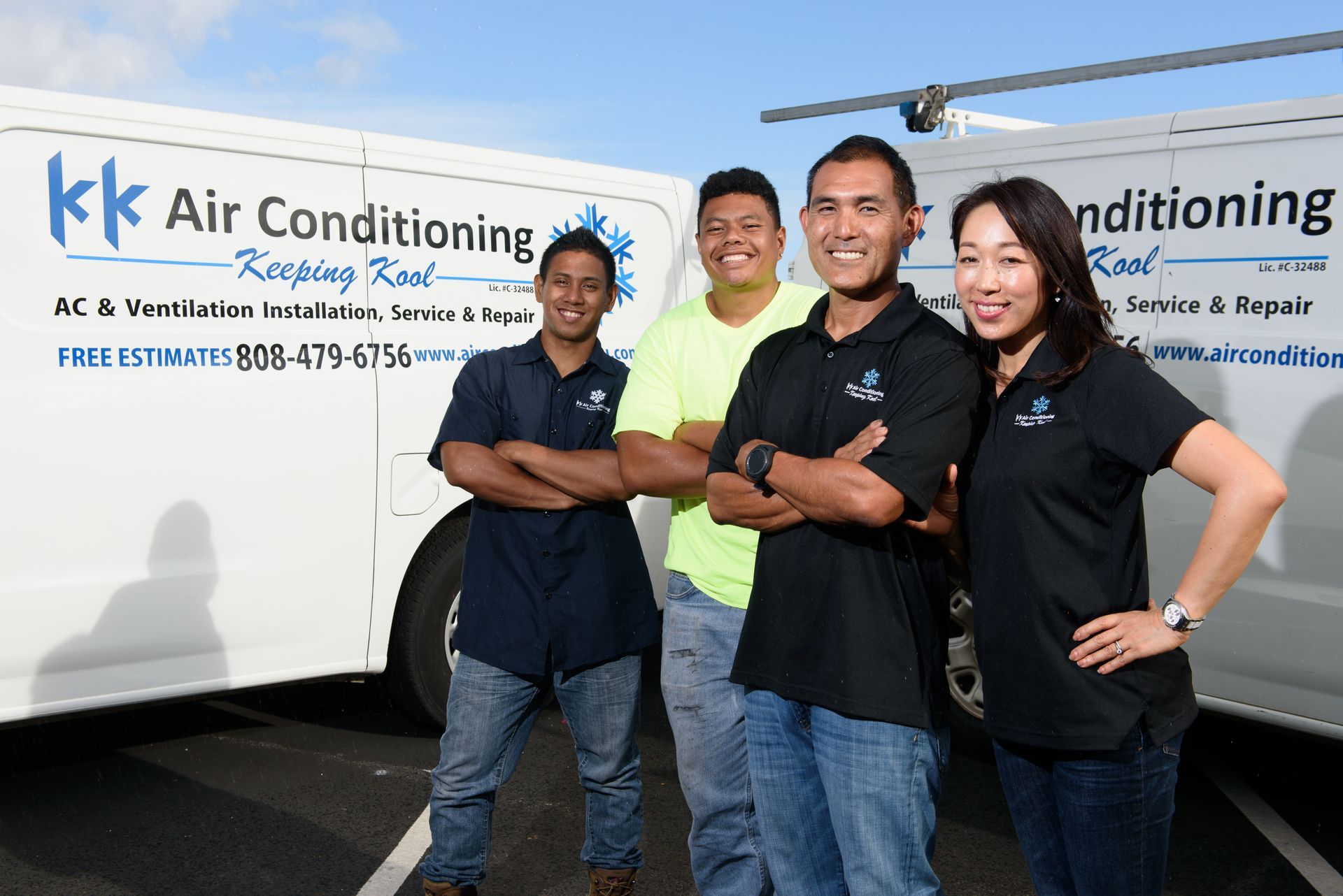 A group of people standing in front of a kk air conditioning truck