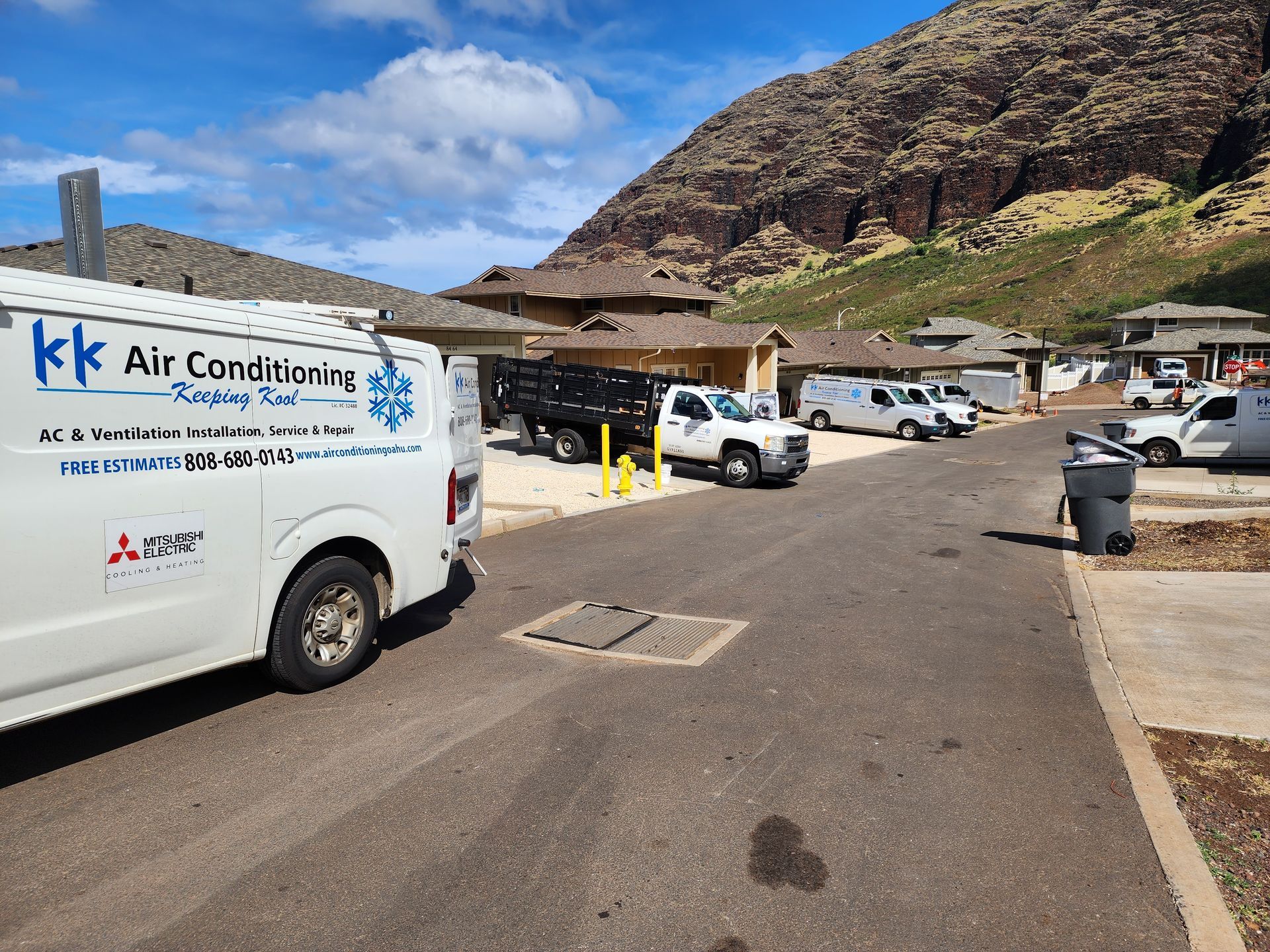 A white air conditioning van is parked on the side of the road.