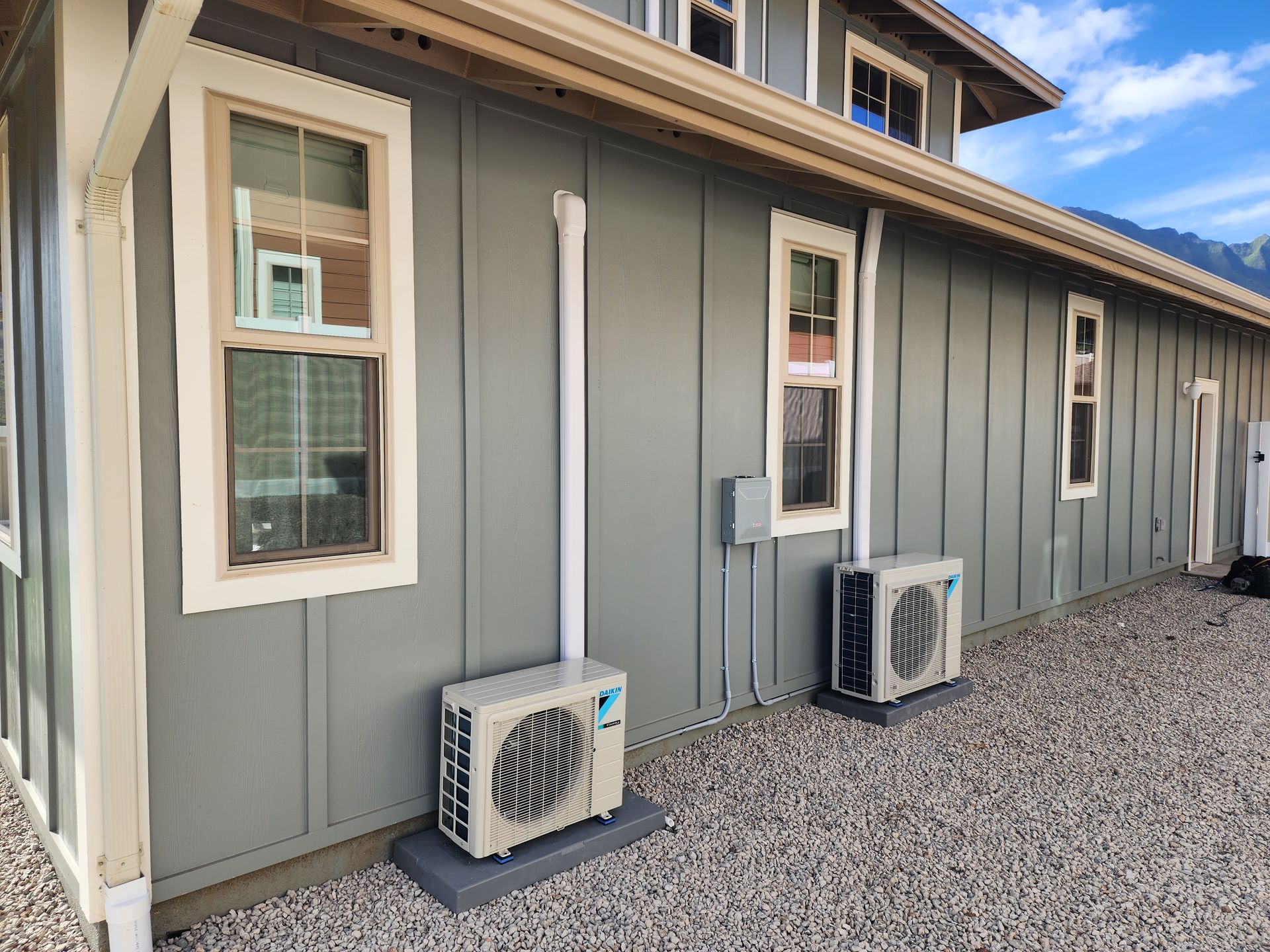 A house with two air conditioners on the side of it.