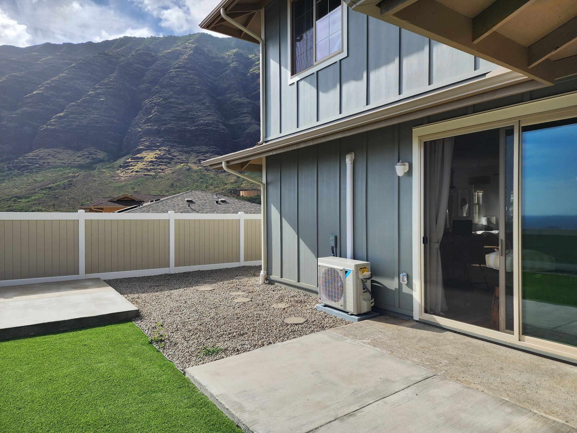 A house with a sliding glass door and mountains in the background.