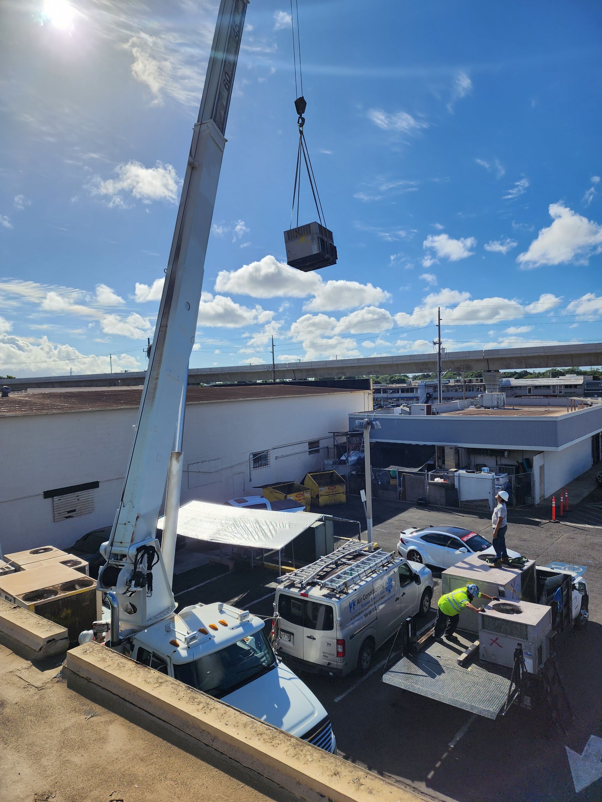 A large crane is lifting a large object into a building.