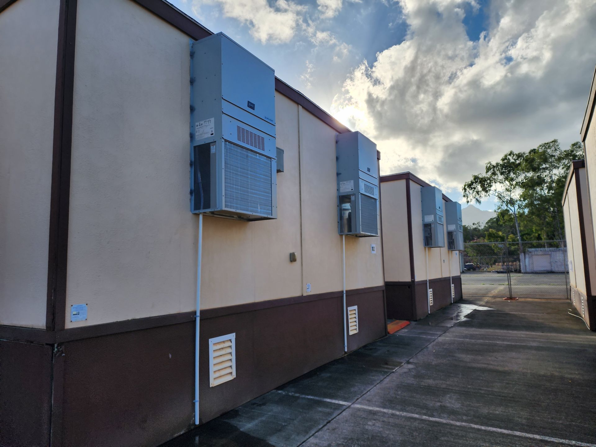 A row of buildings with air conditioners on the side of them.