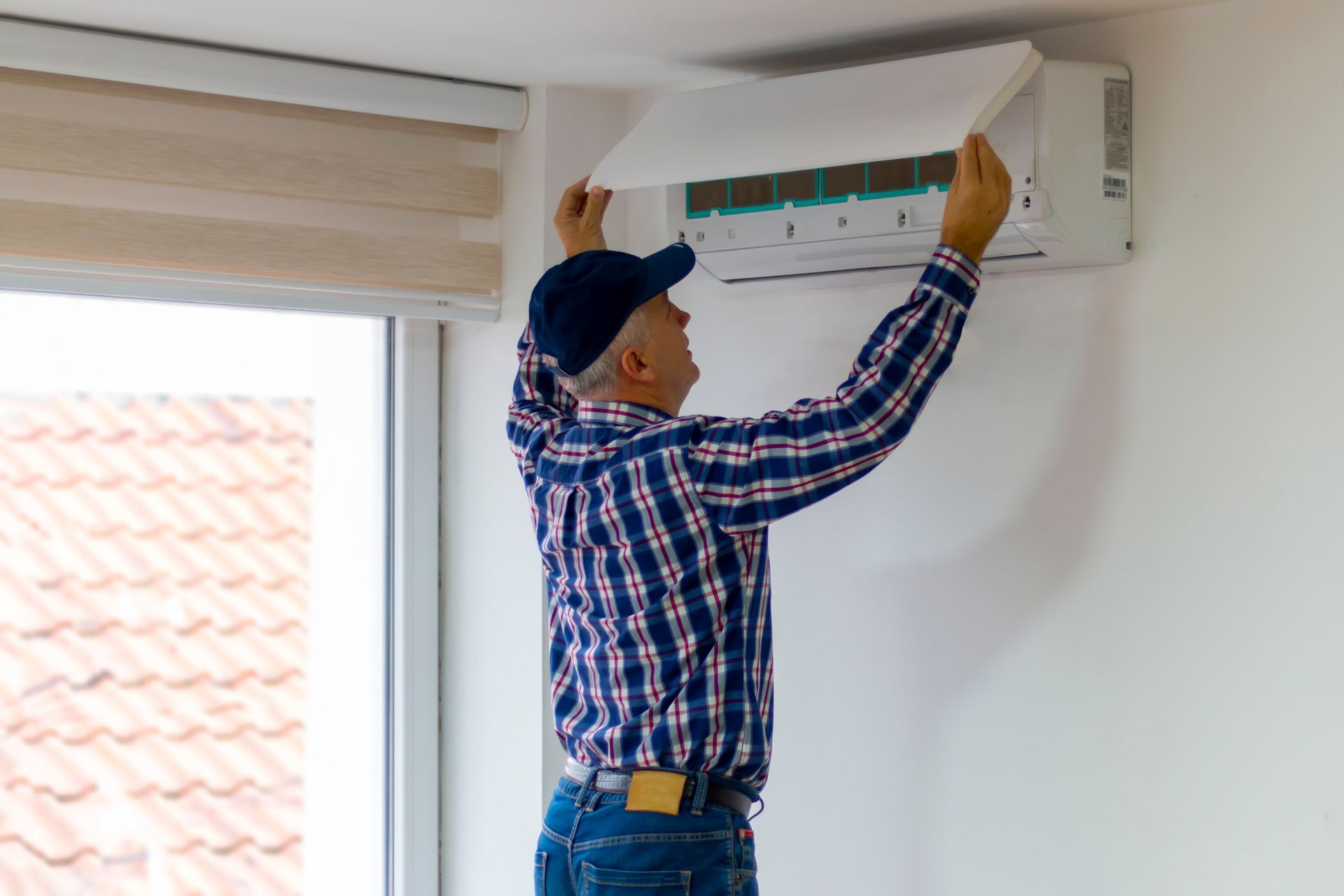A technician removing air filter of the air conditioner for cleaning.