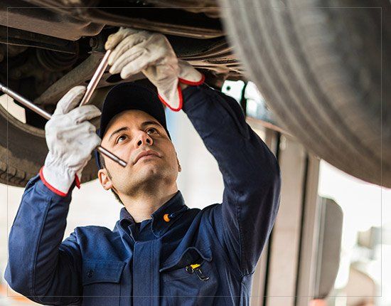 Mechanic repairing a lifted car - Auto Care in Gorham,ME