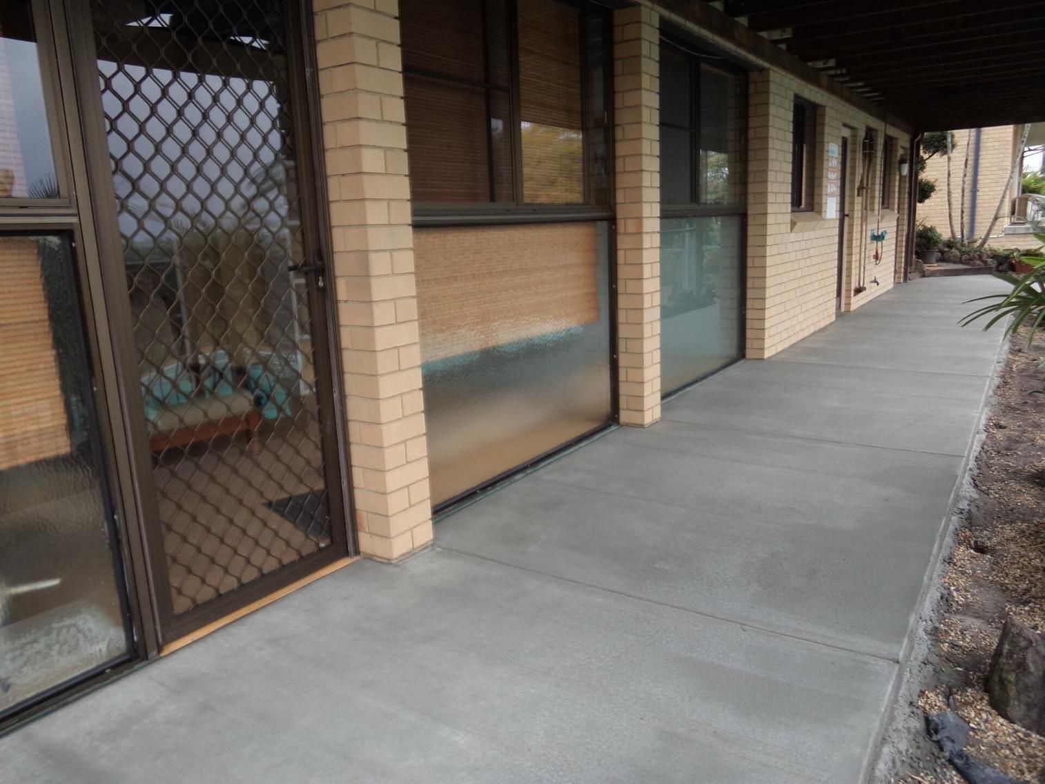 A concrete pathway next to a beige brick house — Wayne Hall Concreting in South Lismore, NSW
