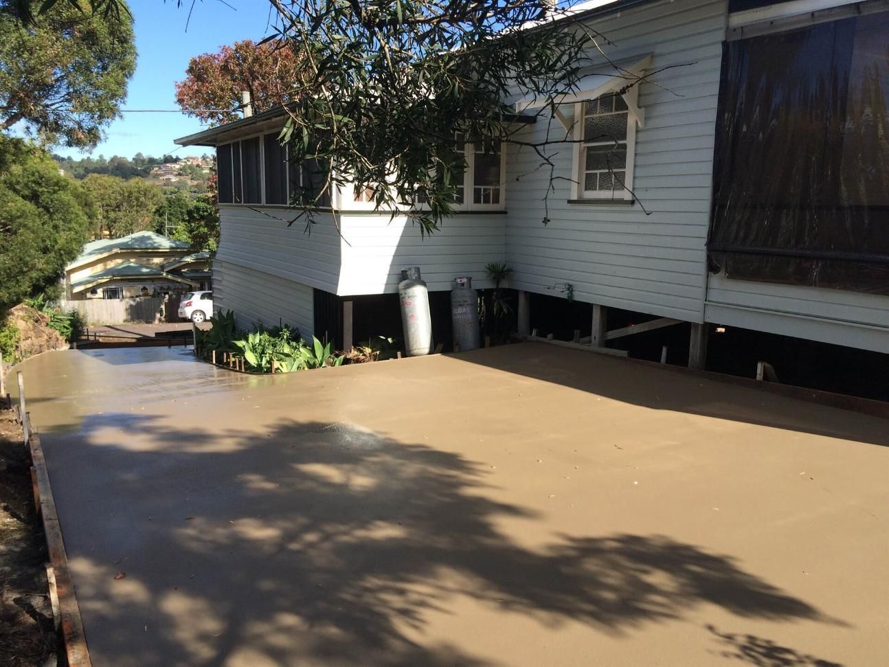 A concrete driveway has just been laid and is unset next to a home — Wayne Hall Concreting in South Lismore, NSW