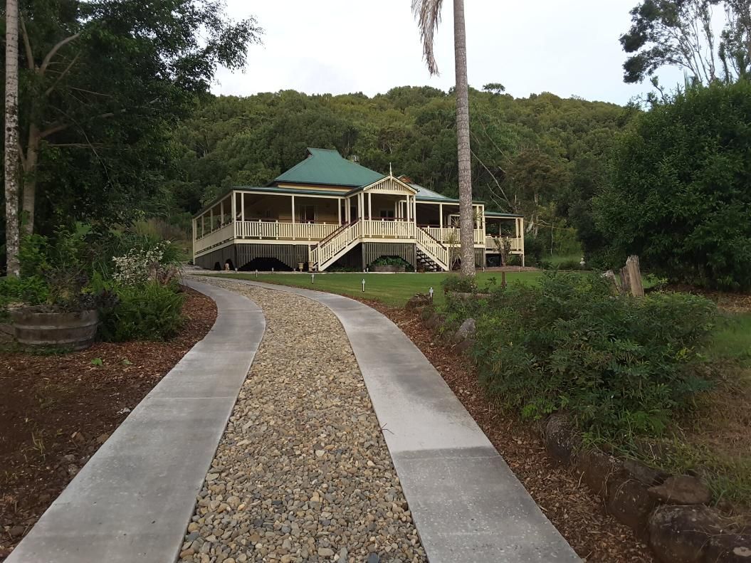 A long concrete driveway is leading to a large home — Wayne Hall Concreting in South Lismore, NSW