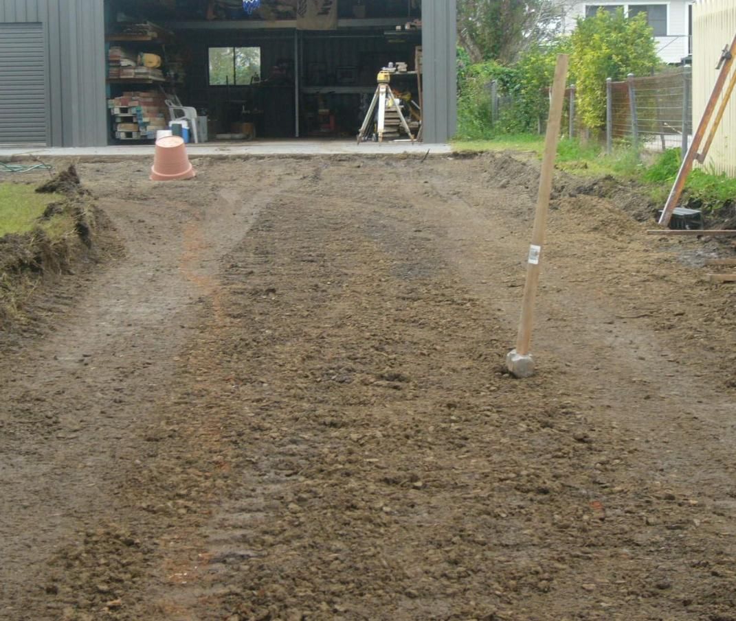 A Dirt Road is Being Built in Front of a Garage — Wayne Hall Concreting in South Lismore, NSW