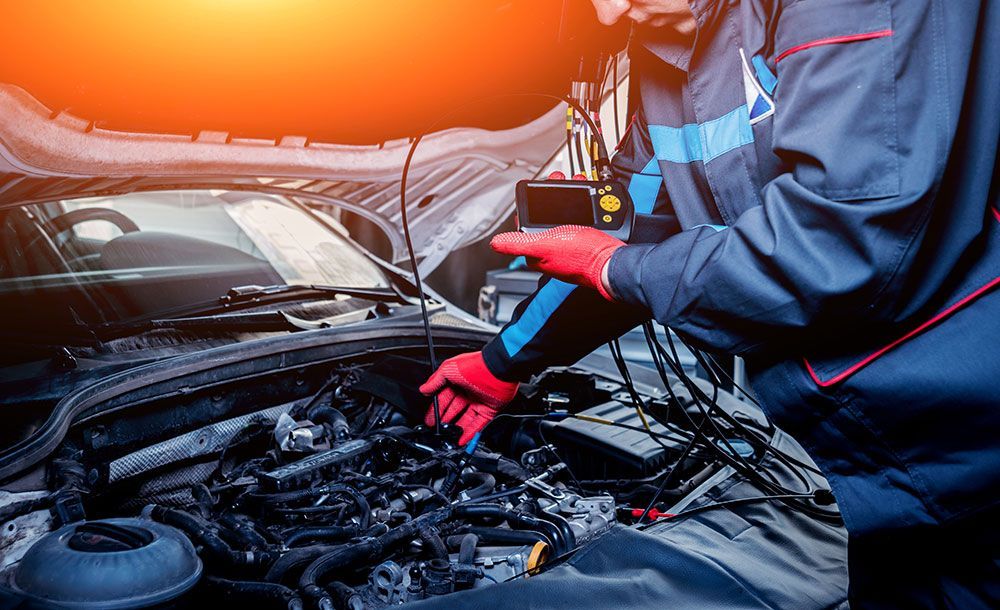 A Mechanic Is Working On The Engine Of A Car — Coffs Harbour Automotive In Coffs Harbour, NSW
