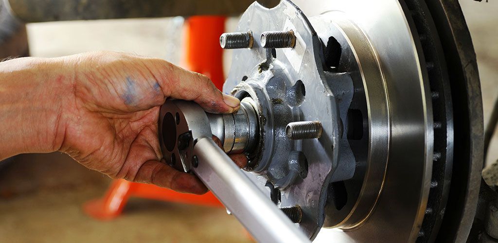 A Person Is Working On A Brake Disc With A Wrench β Coffs Harbour Automotive In Coffs Harbour, NSW