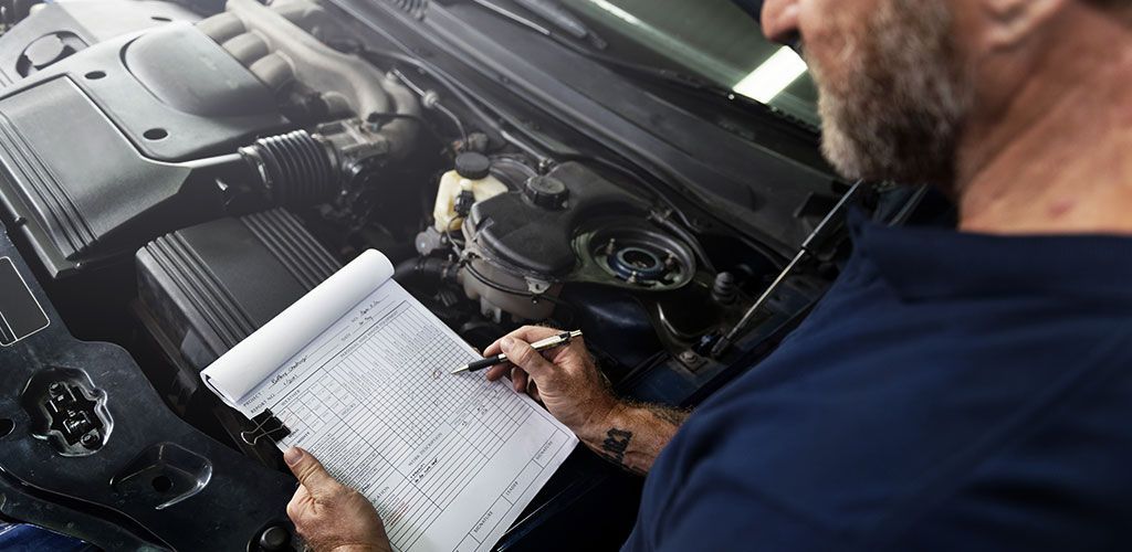 A Man Is Looking Under The Hood Of A Car While Holding A Clipboard β Coffs Harbour Automotive In Coffs Harbour, NSW