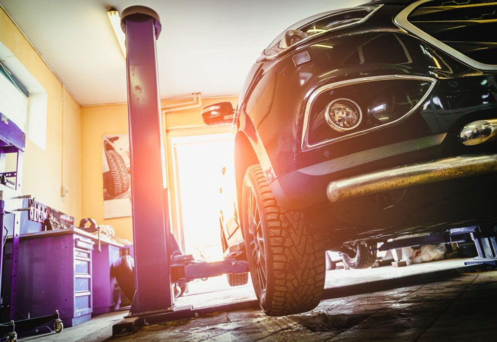 A Car Is Sitting On A Lift In A Garage — Coffs Harbour Automotive In Coffs Harbour, NSW