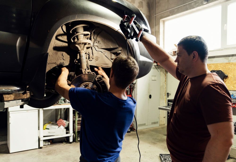 Two Men Are Working On A Car In A Garage — Coffs Harbour Automotive In Coffs Harbour, NSW