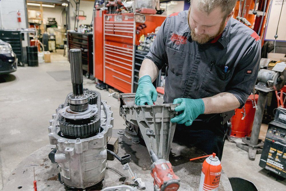 Mechanic working on vehicle transmission | Jamestown Automotive, Inc.