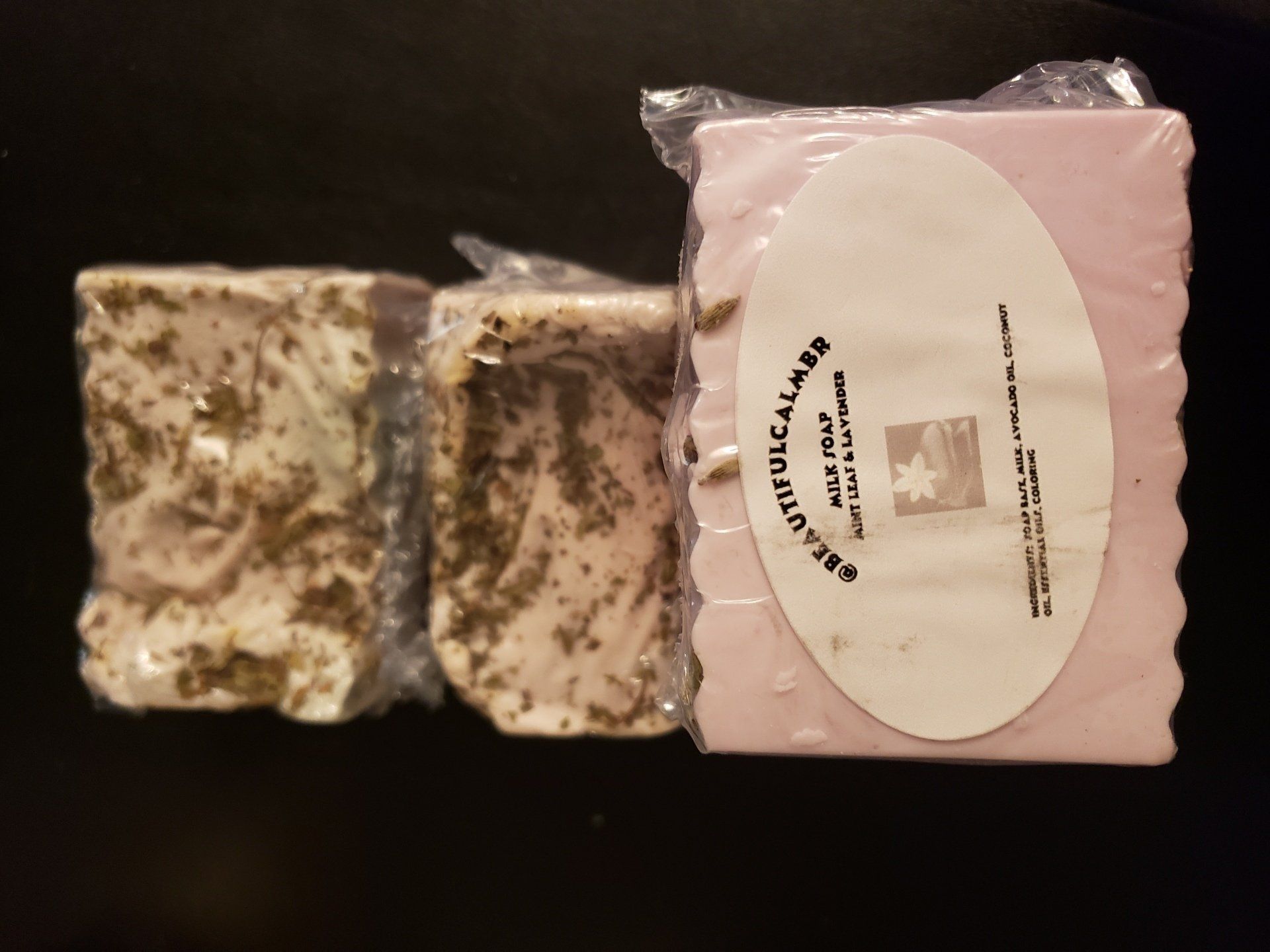 Three pieces of soap are stacked on top of each other on a table.