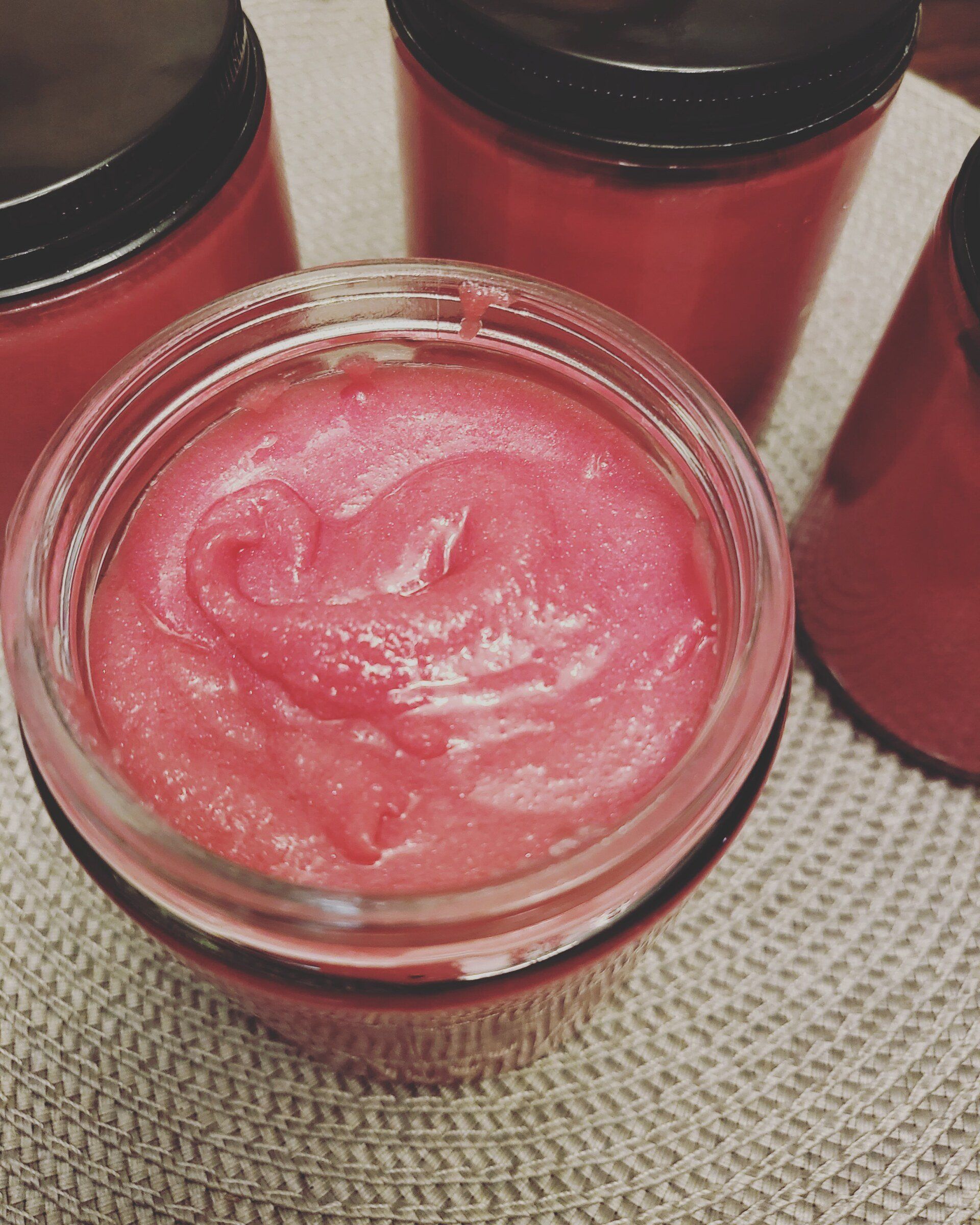 Three jars of body scrub are sitting on a table