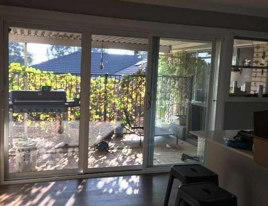 A Living Room with a Sliding Glass Door and Two High Chairs - Penrith, NSW - ClearShield-Penrith