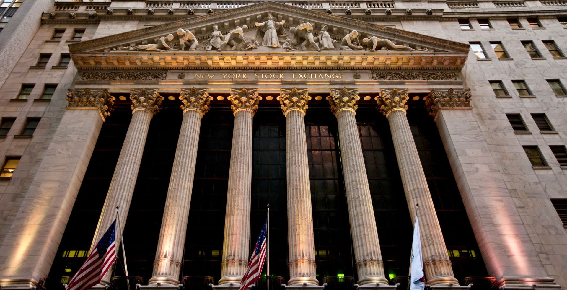New York Stock Exchange building with large columns and flags.