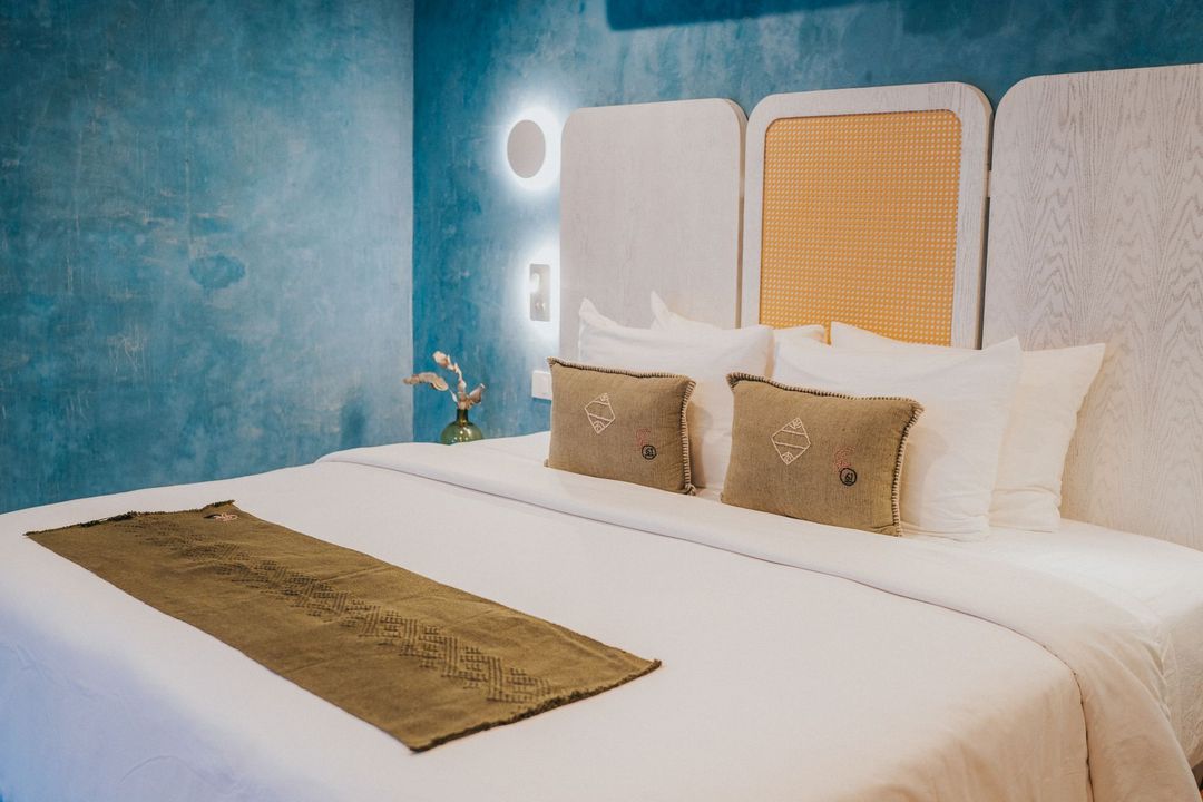 Habitación de paredes azules con una larga mesa blanca y sillas turquesas, 