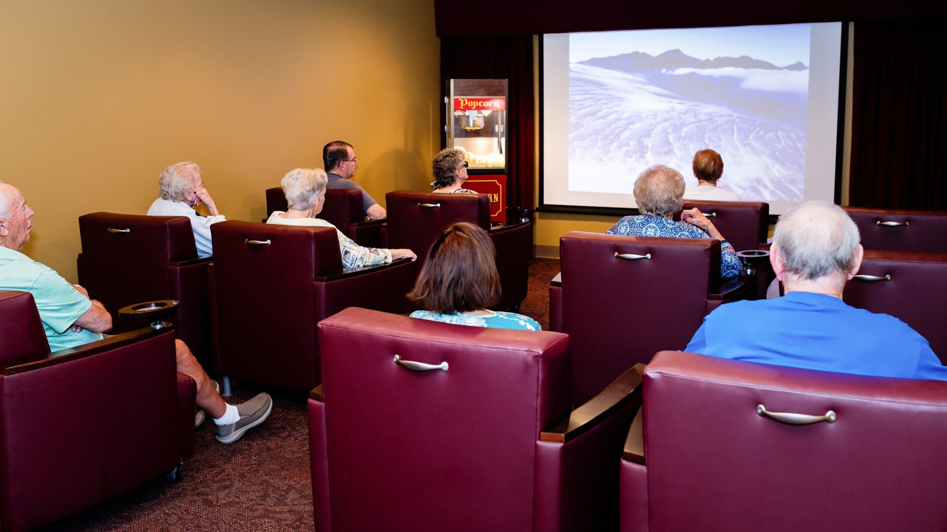A group of seniors sitting in a theater watching a movie.
