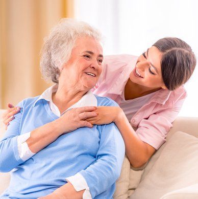 caregiver holding hands with elderly woman