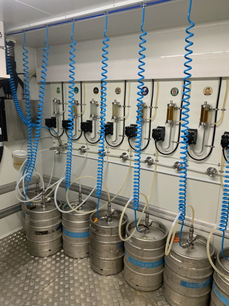 Beer kegs with tap system in a refrigerated interior. Silver kegs and blue hoses are visible.— Elements Air & Refrigeration In Westcourt, QLD