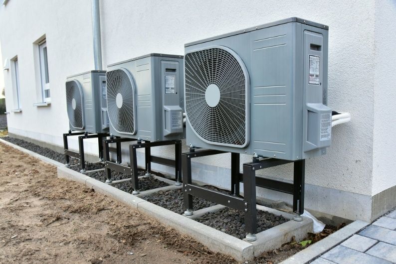 A Row of Air Conditioners Are Sitting on the Side of a Building — Elements Air & Refrigeration In Cairns City, QLD