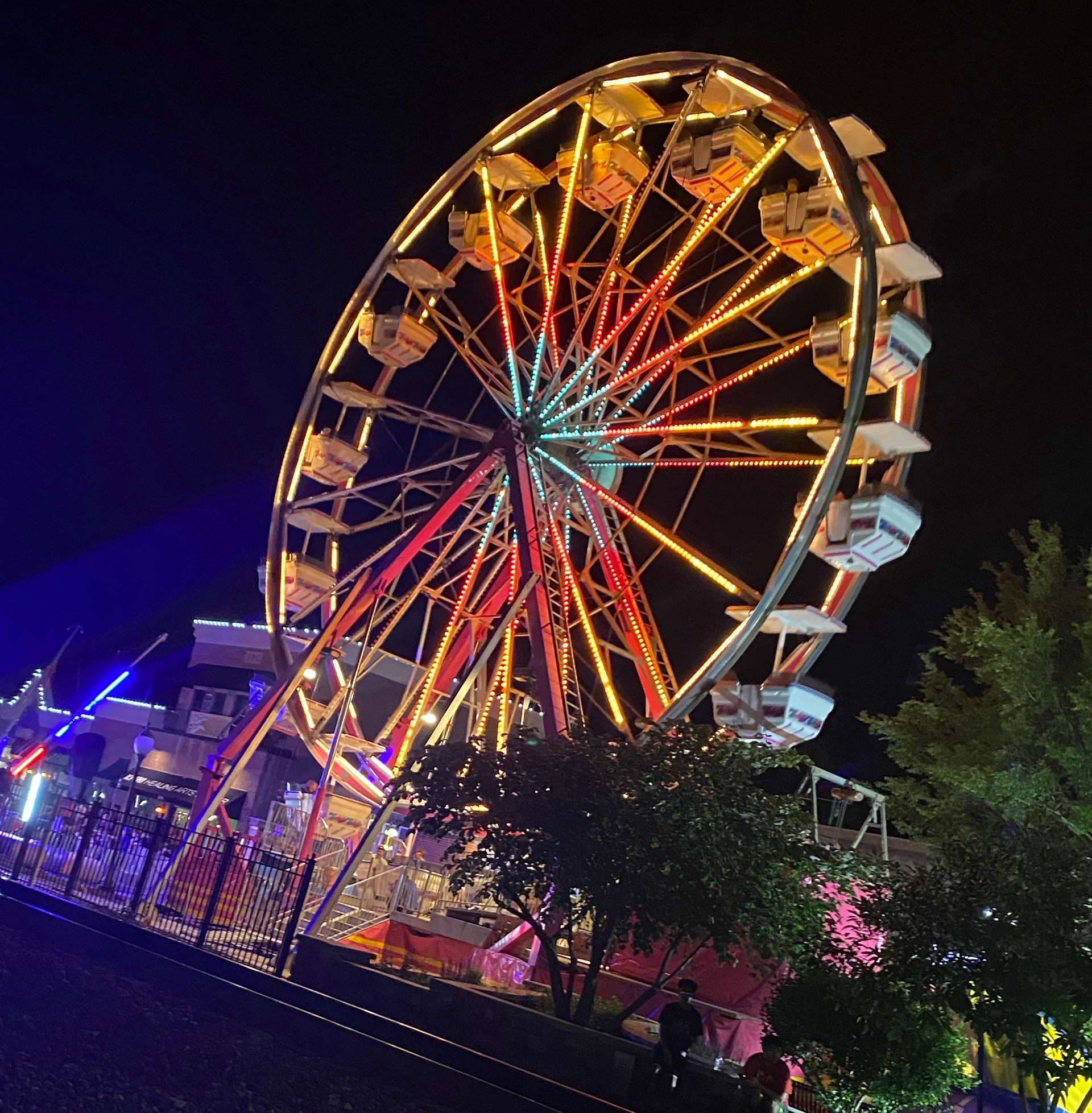 A colorful ferris wheel is lit up at night