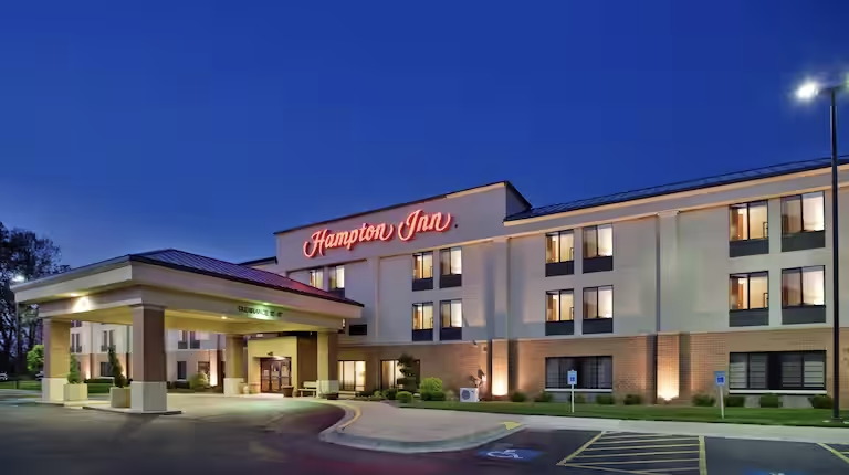 A large hotel with a lot of windows is lit up at night.